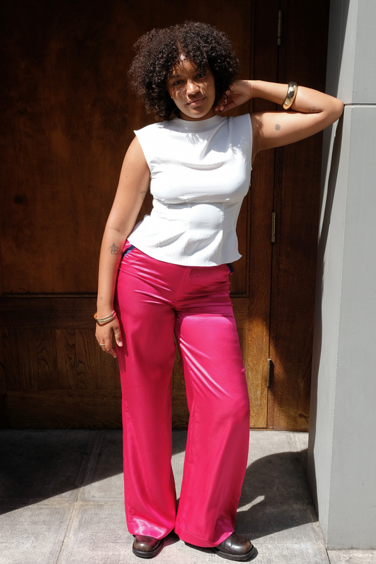 pink wide-leg silk trousers with navy trims, worn in London