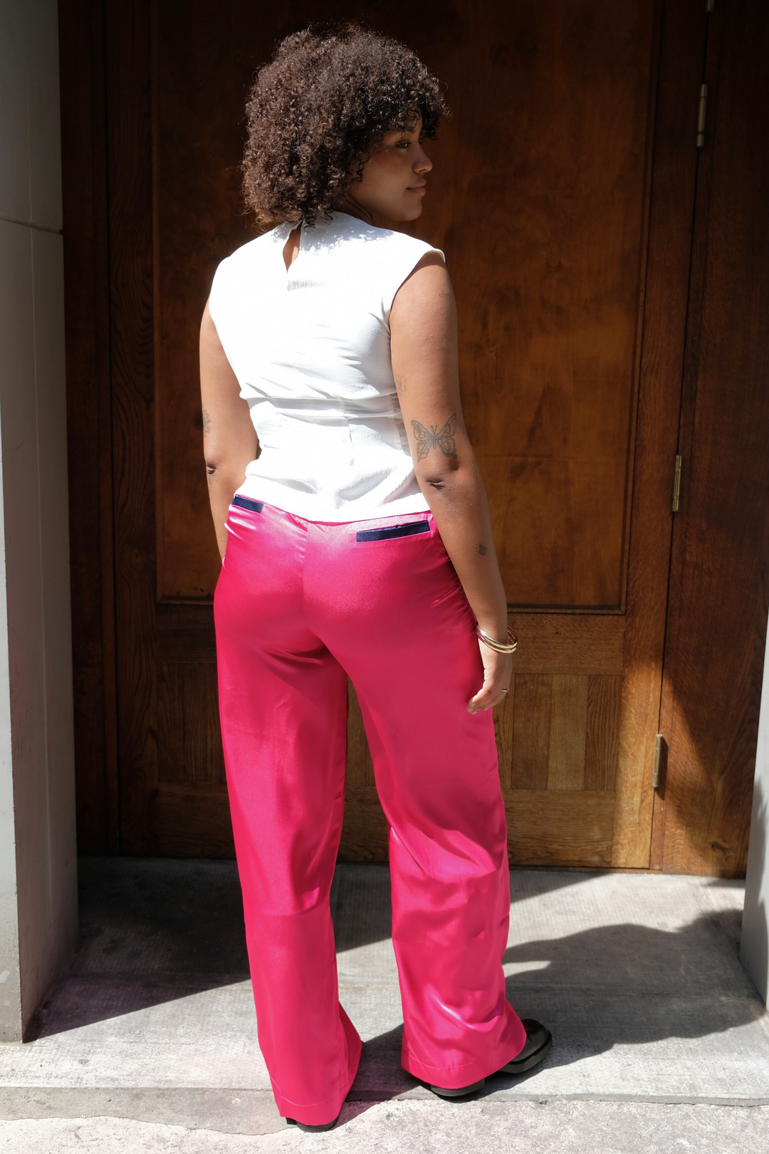 pink wide-leg silk trousers with navy trims, worn in London