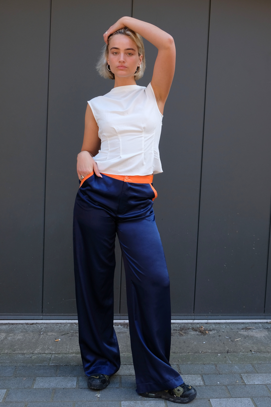 navy silk trousers, wide-leg, with orange contrast trims worn in London